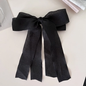 Detailansicht einer großen schwarzen Schleife Haarspange mit eleganten langen Bändern