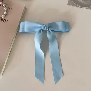 Elegant light blue satin double bow hair clip with long ribbons on a white background