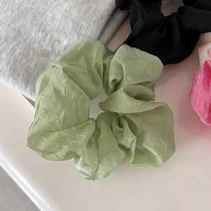 Close-up of translucent pleated organza scrunchies in pistachio green and various colors