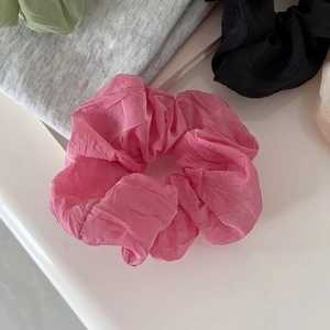 Detail of soft pleated mesh hair scrunchies in pink and various pastel colors