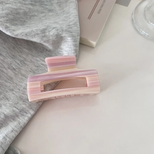 Detailaufnahme des rosa marmorierten Acetats der Haarklammer mit Farbverlauf