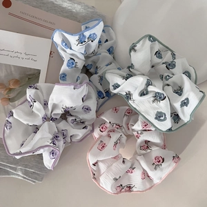Close-up of floral fabric scrunchies in pastel colors with delicate rose patterns