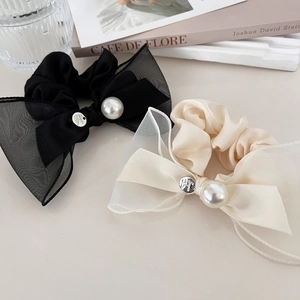 Détail de chouchous élégants en satin avec nœud en résille et perles décoratives