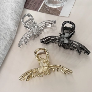 Detailed close-up of metallic butterfly hair clips with elegant cat eye stone inlay