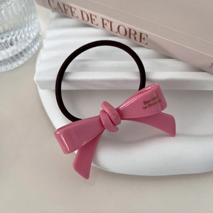 Close-up of pink acetate bow hair tie featuring a golden Barrette La France inscription