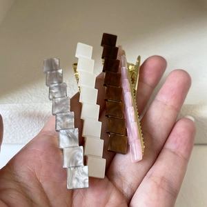 Minimalist geometric acrylic hair clips in neutral colors with gold duckbill clips