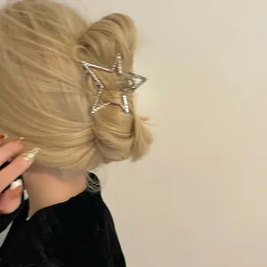 Sparkling star hair claw clip with rhinestones worn on blonde hair for elegant half-up style