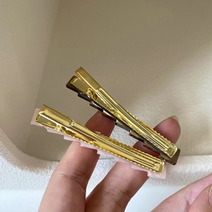 Close-up of pink and brown geometric hair clips with gold metal base for women