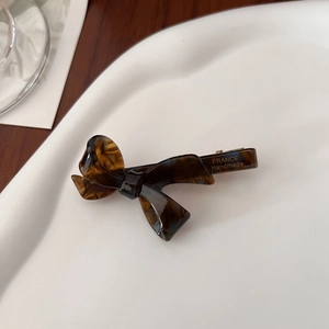 Close-up of tortoise shell bow hair clip with FRANCE Handmade engraving on the metal base