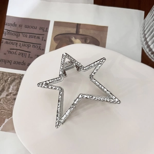 Minimalist silver star hair claw clip with hammered metal texture in a stylish setting