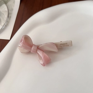 Detail showing the pink acetate bow hair clip with FRANCE Handmade engraving