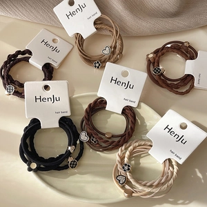 Close-up of elastic heart hair ties in earth tones on a white display card