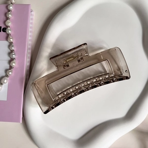 Detailed view of large translucent tea brown rectangle hair claw clip with metallic spring