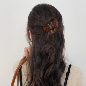 Elegant amber heart acetate hair claw clip shown on model for back-of-head styling