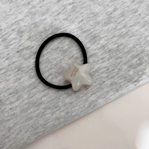 Détail de l'élastique à cheveux avec étoile crème et inscription France handmade