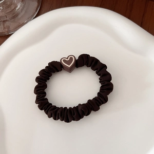 Detailed macro view of dark brown elastic scrunchie with chocolate heart decoration