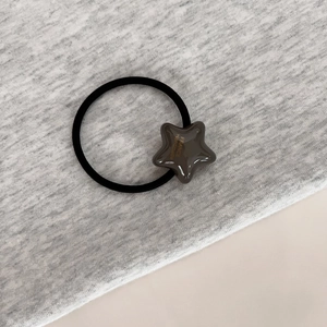 Détail d'un ornement en étoile marron avec texte France Handmade doré sur élastique noir