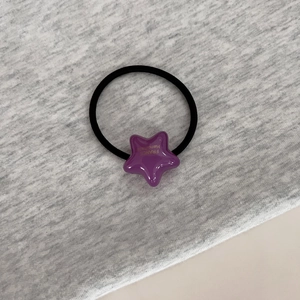 Détail d'un élastique noir haute élasticité avec pendentif étoile en résine violette