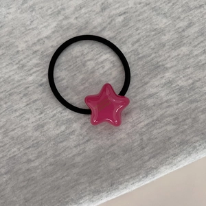 Détail d'un charm étoile rose sur élastique à cheveux noir avec lettrage fait main