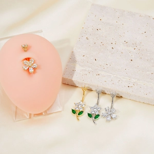 Vue détaillée des piercings de nombril fleur à cinq pétales avec zircons sur un modèle