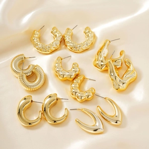 Set of six pairs of vintage gold-plated geometric earrings on champagne silk background