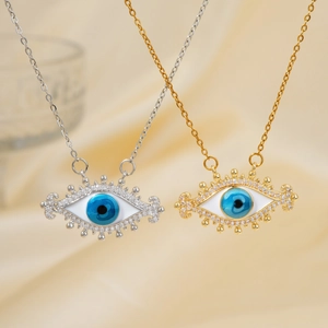 Detailed view of silver and gold evil eye necklaces with blue zircon inlay on silk cloth