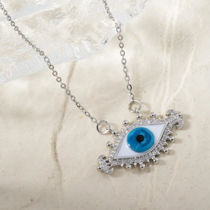 Close-up of evil eye pendant with blue enamel and sparkling zircons on silver chain