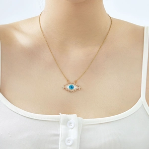Close-up of a gold necklace featuring a blue evil eye pendant with white zircon stones