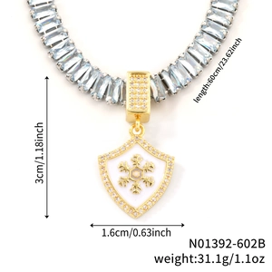 Détail du pendentif bouclier avec flocon doré et collier de pierres bleues