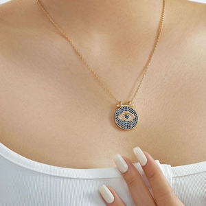 Primer plano del collar ojo turco dorado con diamantes azules en el cuello