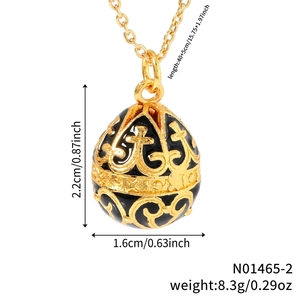 Vintage gold egg pendant necklace with black enamel floral patterns on white background