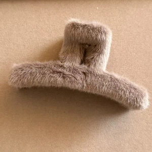 Detail view of large plush khaki faux fur claw clip with a square hollow design