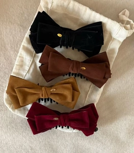 Detail view of velvet bow hair clips in four colors with gold Love metal plates