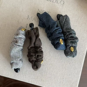 Set of four textured fabric banana hair clips in vintage grey, brown, and navy colors