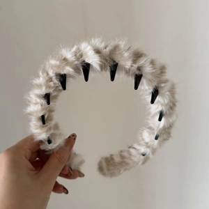 Détail d'un serre-tête en peluche beige avec des dents intérieures antidérapantes noires
