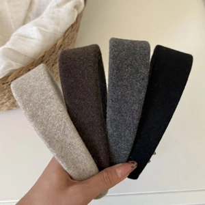 Close-up of four wool-textured headbands in beige, brown, grey, and black colors