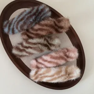 Barrettes à cheveux en peluche rayée aux couleurs d'automne dans un plateau élégant