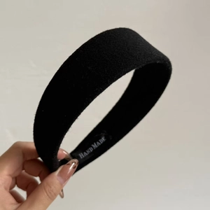 Detailed macro view of black wool-like velvet headband with Hand Made inner label