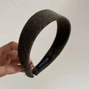 Detailed macro view of the handmade woven label on a grey wool thick sponge headband