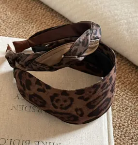 Detail von geflochtenem Leoparden-Haarreif und Samt-Haarband in Vintage-Brauntönen