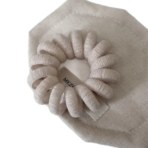 Élastique à cheveux spirale en velours beige sur carte de présentation