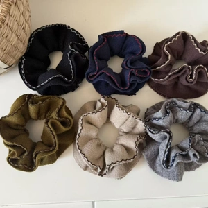 Détail de six chouchous en tricot avec coutures contrastées et un petit panier tressé