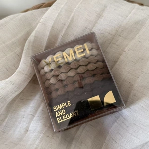 Neutral-toned elastic hair ties set in a transparent gift box with wave pattern design