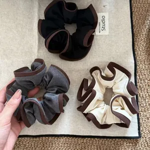Three vintage fabric hair scrunchies with brown piping in black, grey, and cream white