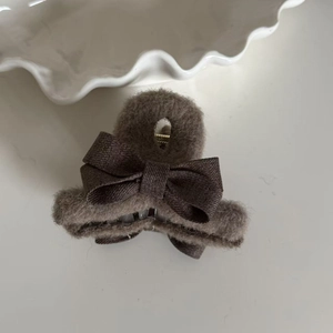 Detail of brown plush bow hair claw clip with velvet fabric and sturdy metal spring