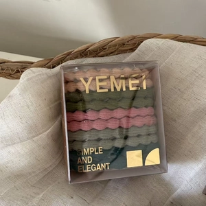 Detailed view of elastic hair ties in a clear gift box with golden YEMEI logo