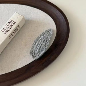 Gray wavy knit wool hair clip in droplet shape with handmade crochet leaf pattern