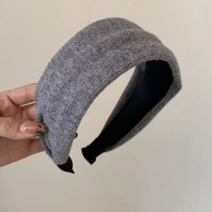 Detail view of thick grey knit headband with wool-like texture and soft black inner lining