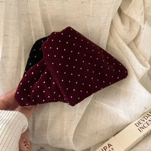 Close-up of velvet hair clips with elegant pearl dots in burgundy red and black colors