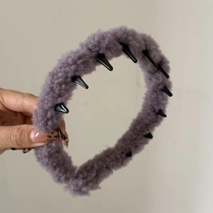 Détail du serre-tête en peluche violette montrant la texture douce et les dents internes